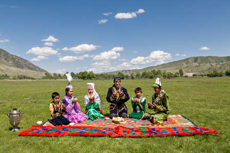 Kazakh family praying all together before they start having their picnic lunch in Saty Village, Kazakhstan.のeditorial素材
