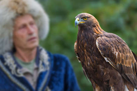 Kazakh eagle hunter in traditional costumes and his golden eagle in Almaty, Kazakhstan.