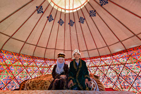 Kyrgyz couple in national costumes, in a nomadic tent known as yurt, near the city of Bishkek, Kyrgyzstanのeditorial素材