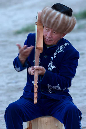 Local man playing traditional Kyrgyz musical instrument known as Komuz, in Issyk Kul Lake, Kyrgyzstanのeditorial素材
