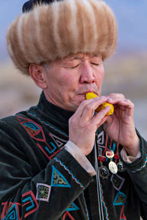 Kyrgyz musician plays traditional musical instrument known as Choor, in Issyk Kul, Kyrgyzstan