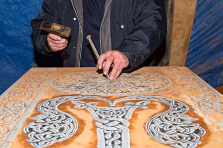 Hands carving traditional Armenian tombstones known as Khachkars.の写真素材