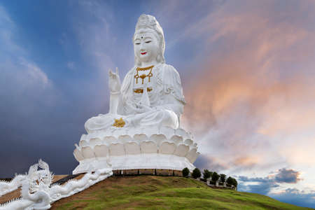 Big Guan Yin Statue representing goddess of compassion and mercy, at the sunset, in Chiang Rai,...