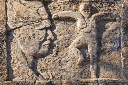 Sculpture over a rock wall representing Ataturk and a person performing local folk dance of Zeybek, in Birgi, Turkey.のeditorial素材