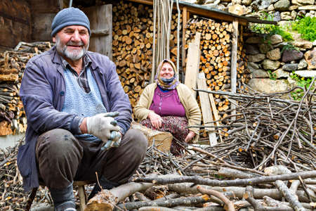 Elderly Turkish couple smiling and looking while chopping the fire wood in Trabzon, Turkey.のeditorial素材
