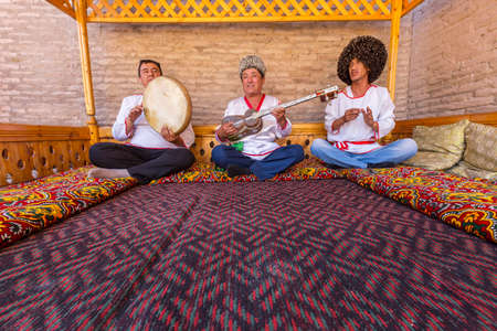 Khorezmian musicians in traditional dresses playing and singing  local songs in Khiva, Uzbekistanのeditorial素材