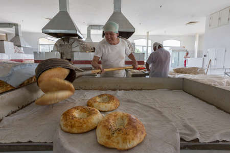 Making bread in a bakery in the Chorsu Bazaar in Tashkent, Uzbekistan.のeditorial素材