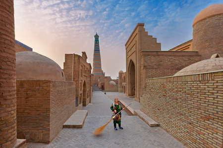 Local woman sweeping the street, in Khiva, Uzbekistan.のeditorial素材
