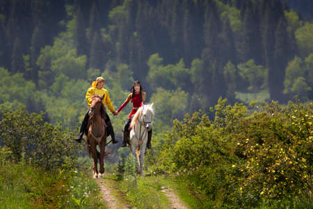 Kazakh couple in national costumes hand in hand on their horse in Almaty, Kazakhstan.のeditorial素材