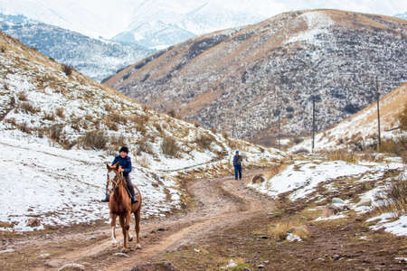 Nomadic young boy riding horse near Bishkek, Kyrgyzstanのeditorial素材