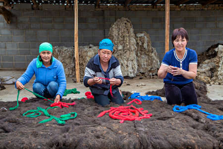 Kyrgyz women making felt carpet in traditional way, in Issyk Kul, Kyrgyzstan.のeditorial素材
