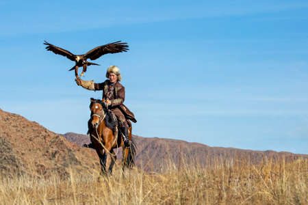 Eagle hunter and his Golden Eagle in Issyk Kul, Kyrgyzstan