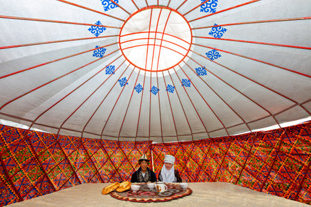 Kyrgyz couple in local clothes, in a nomadic tent known as yurt, near Bishkek, Kyrgyzstan.のeditorial素材