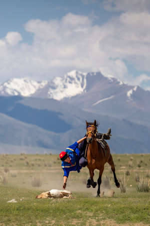 Nomadic horse rider with the goat carcass during traditional nomadic horse games known as Buzkashi or Kok Par, in Issyk Kul, Kyrgyzstan.のeditorial素材