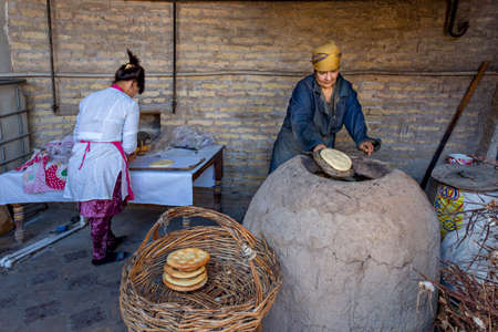 Uzbek women making tandoori bread in Khiva, Uzbekistan.