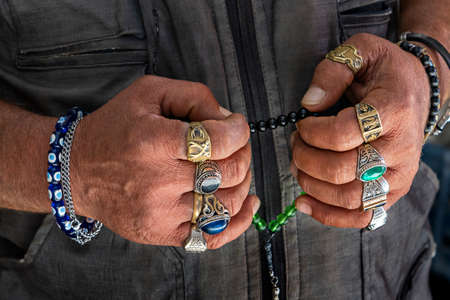 Hands wearing rings and holding worry beads, Turkeyの写真素材