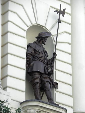 Bronze statue of a soldier in the niche of a medieval building.の写真素材