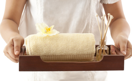 Woman holding a tray with towel and reed diffuserの写真素材