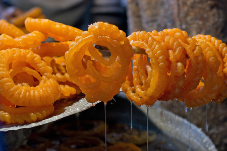 Delicious jhangri jalebis hanging on stick at stall