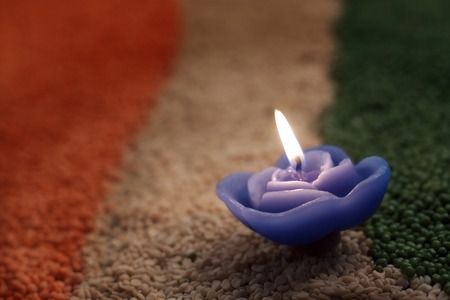 A candle in the middle of coloured pulsesの写真素材
