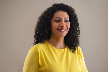 Portrait of a young woman with curly hair smilingの写真素材