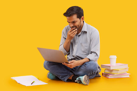 Young man sitting down and using laptop