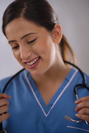 Close-up portrait of a young beautiful female nurse against plain backgroundの写真素材