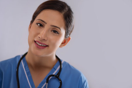Close-up portrait of a young female nurse against plain backgroundの写真素材
