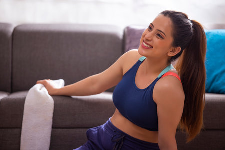 Portrait of a young woman in sportswear sitting at homeの写真素材