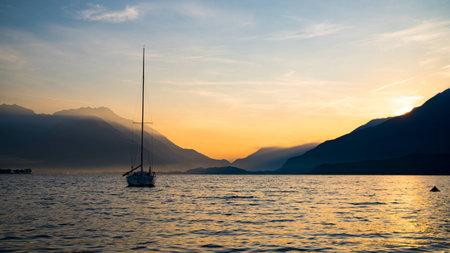 Sunrise on Lake Como with boat on the waterの写真素材