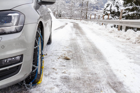 Car with snow chains on a smooth road in winter