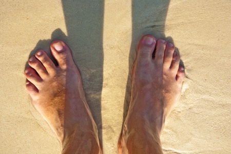 feet of a man in the fine sand