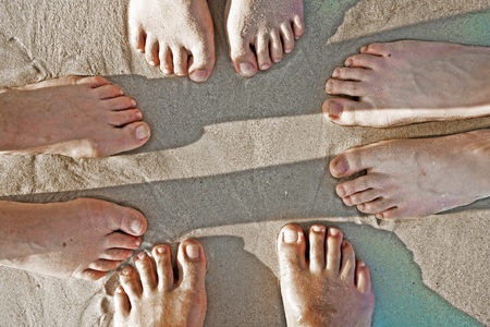 feet of a family in the fine sand of the beached, grouped in a circleの写真素材