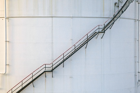 white tanks in tank farm with iron staircase in snowの写真素材