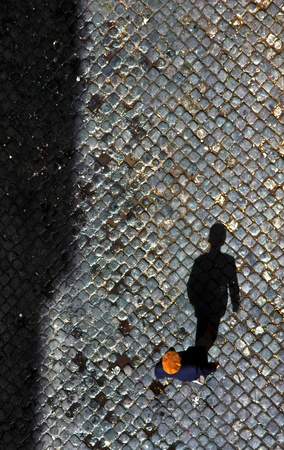 man walking on cobble stone  in Lisboa with his shadowの写真素材