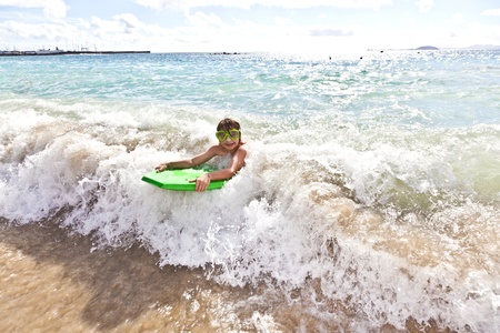 boy has fun with the surfboard at the beach