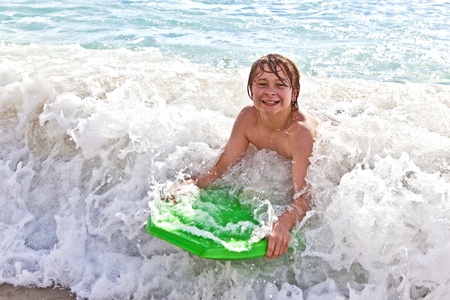 boy has fun with the surfboard at the beach