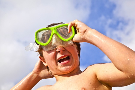 boy has fun with the diving mask at the beachの写真素材