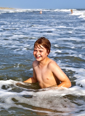 boys enjoying the beautiful ocean with wavesの写真素材