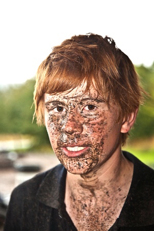 boy has dirt in his face from driving Quad in rain