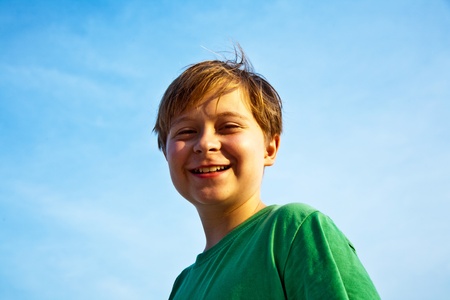 happy smiling young boy with background blue skyの写真素材