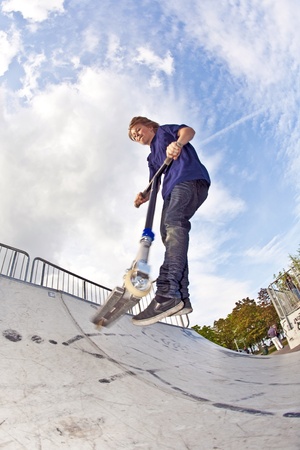 young boy going airborne with his scooterの写真素材