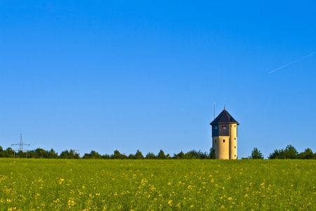 watertower with rape fields in blue skyの写真素材