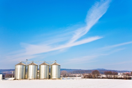 beautiful landscape with silo and snow white acre with blue skyの写真素材