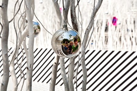 white painted branches give a harmonic background with chrismas tree balls and mirroring of a familyの写真素材