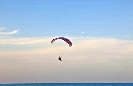 Paraglider flying over the beach with a paramotor