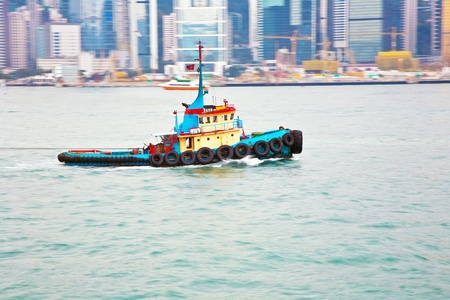 Landscape of Victoria Harbor in Hong Kong with famous star ferry on the ocean with tall buildings and skyscrapersの写真素材