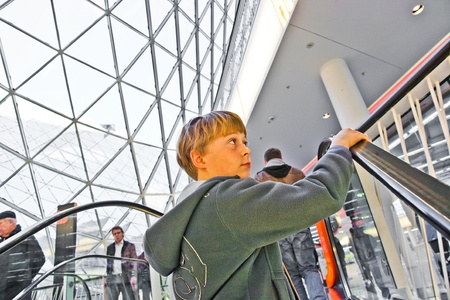 child on moving staircase looks self confident and smilesの写真素材