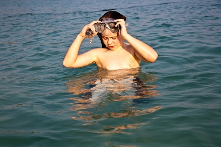 young boy is standing in the beautiful clear sea, enjoying the water and starts snorkelingの写真素材