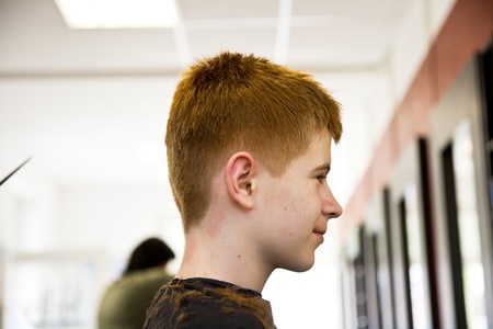 smiling young boy with red hair at the hairdresserの写真素材